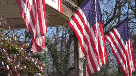 american flags hanging from the porch of an old house