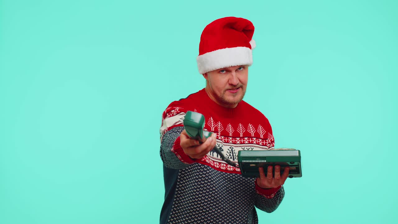 크리스마스 스웨터를 입은 재미있는 남자가 80년대 유선 빈티지 전화기로 통화하며 '안녕 나한테 다시 전화해'라고 말합니다.