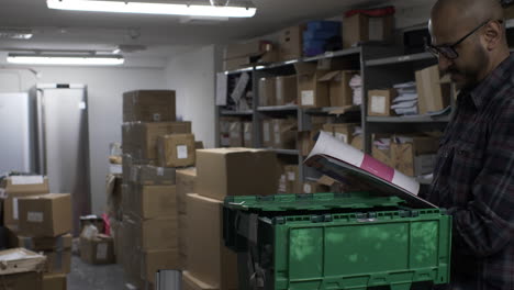 adult ethnic minority male browsing through publication in basement