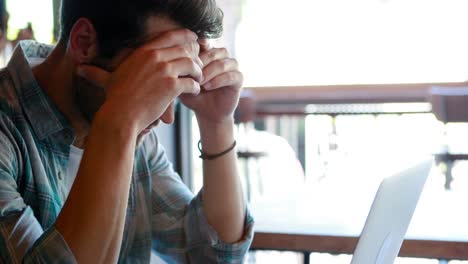 tensed man using laptop while having coffee