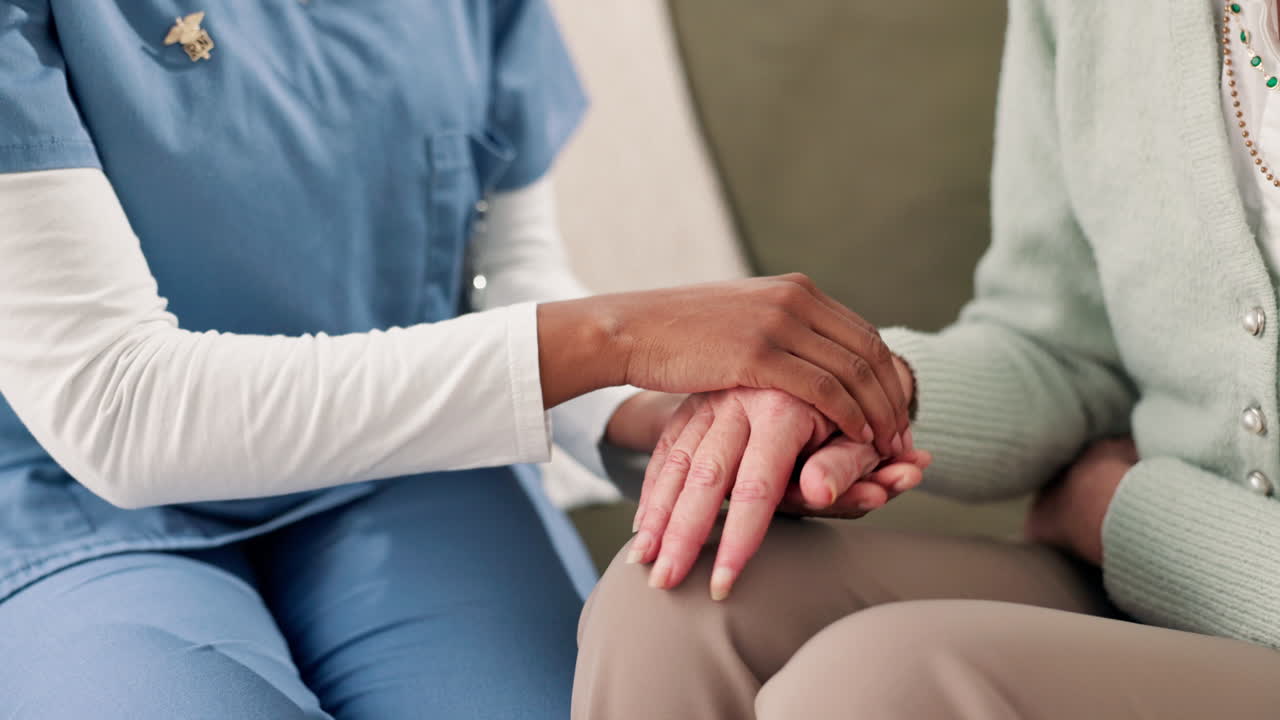 Nurse holding senior patient's hands
