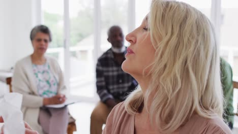 Two-diverse-senior-couples-sitting-in-circle-having-a-therapy-conversation-at-home