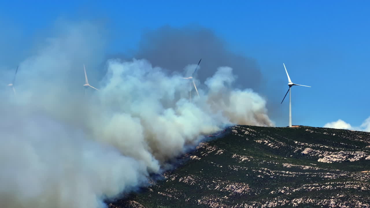 Wildfire engulfs the mountain peak of Valdevaqueros in Tarifa, Spain. Flames rage to the summit due to extreme heat and dryness, creating a dramatic and destructive scene.