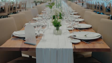 Elegant wedding reception table set with white tableware and floral decorations