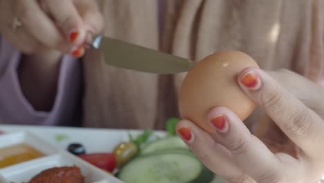 woman peeling an egg for breakfast