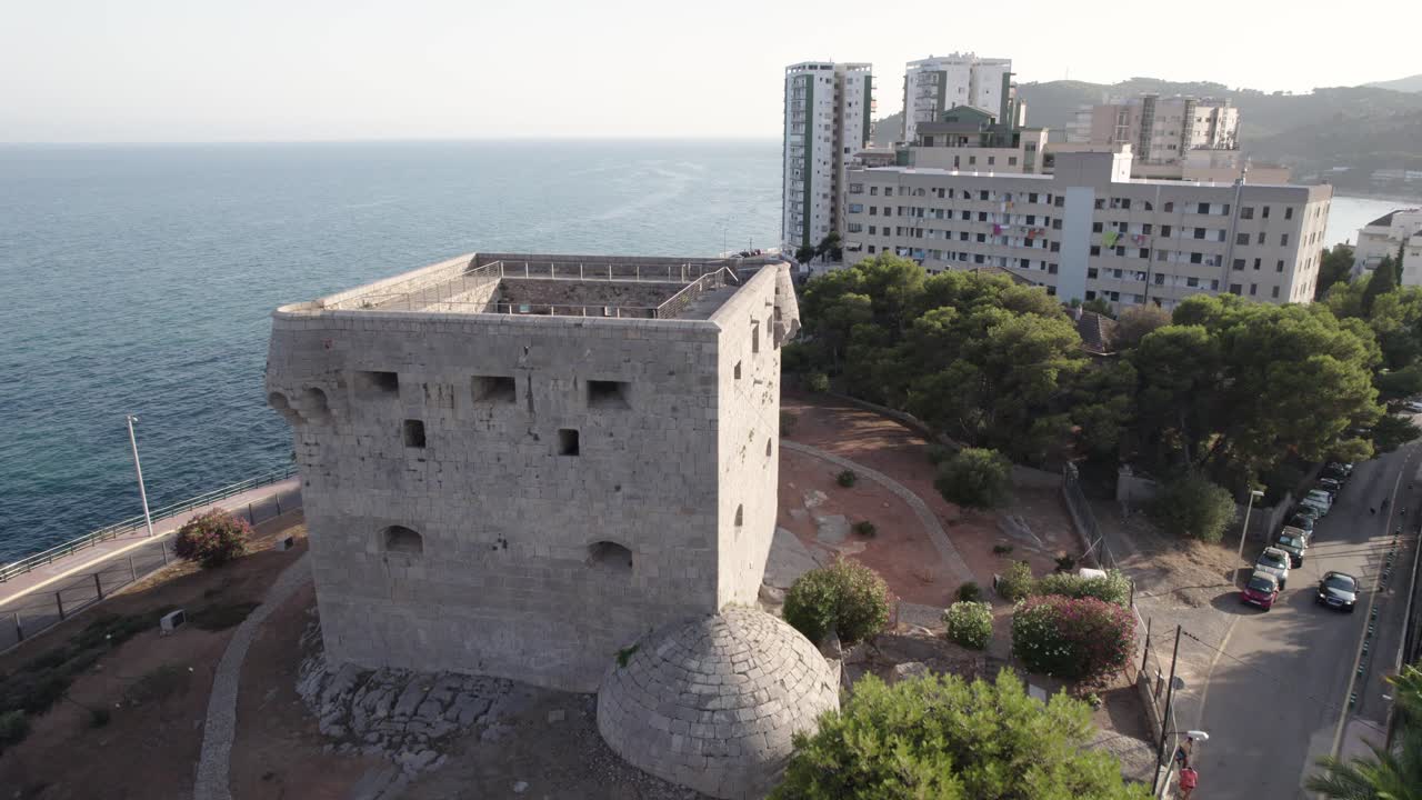 vuelo de drones de 4k sobre la antigua torre de piedra cuadrada medieval defensiva de oropesa del mar junto al mar mediterráneo, españa