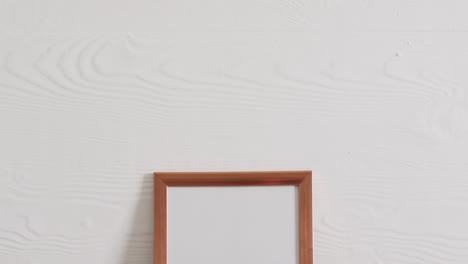 wooden frame with copy space on white background and white wall