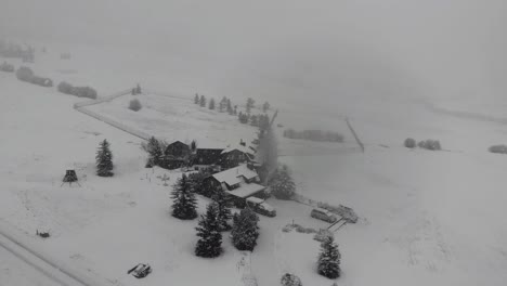 Toma-De-Drones-De-Una-Casa-De-Troncos-En-El-Campo-Durante-Una-Intensa-Ventisca