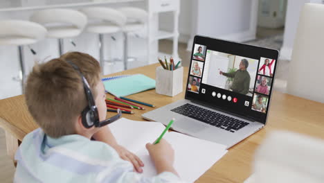 composite of boy using laptop for online lesson at home, with diverse teacher and class on screen