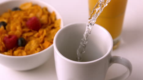 Agua-Y-Bolsitas-De-Té-En-La-Taza-En-La-Mesa-Del-Desayuno.