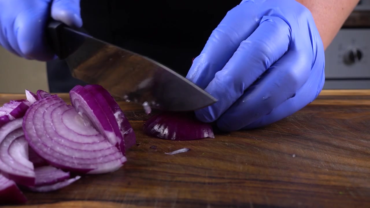Il cuoco taglia le cipolle su un tagliere