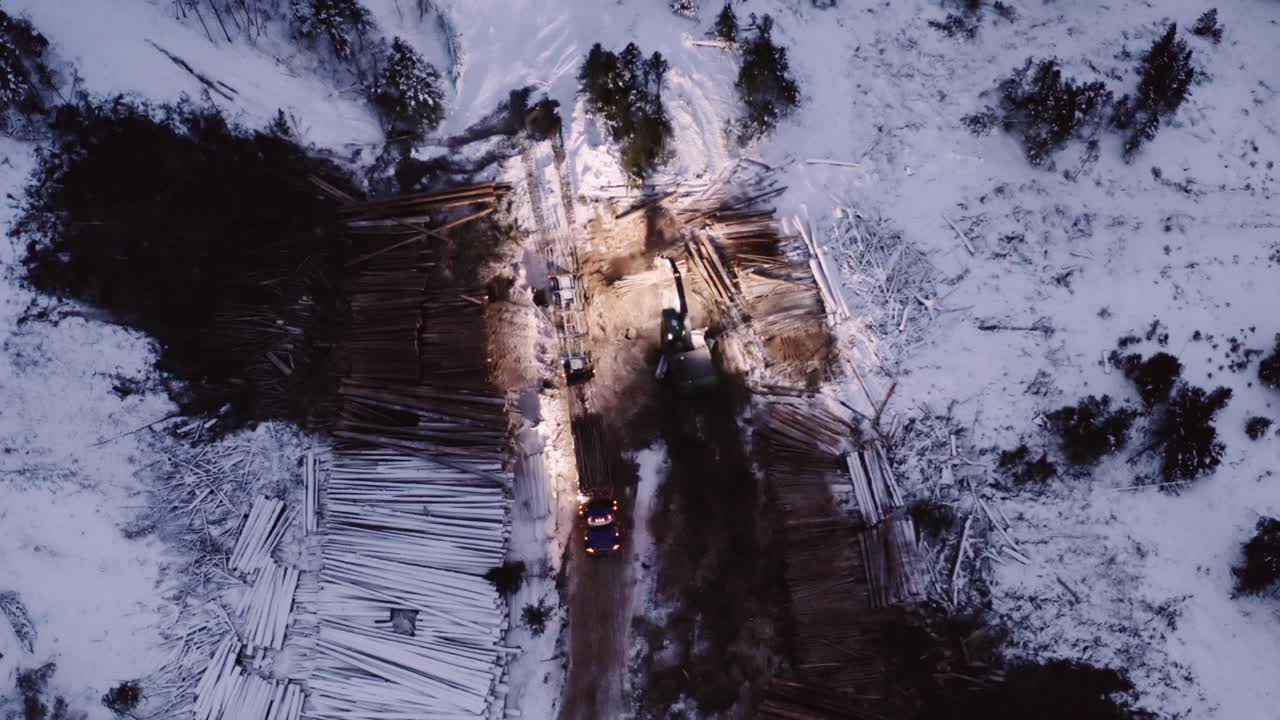 일출 전 이른 아침에 겨울에 이동하는 산업용 목재 벌목 산업 위에서 안정적으로 관찰하는 공중 드론