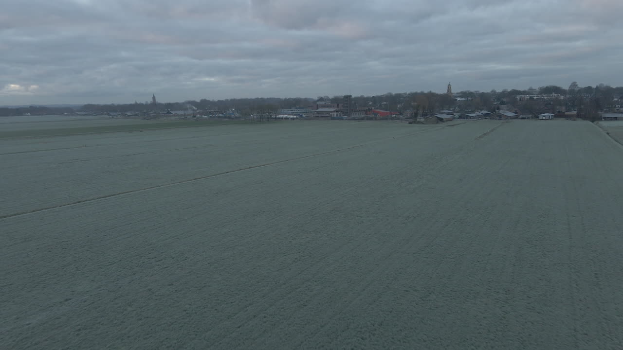 마을의 스카이라인을 배경으로 얼어붙은 초원의 공중