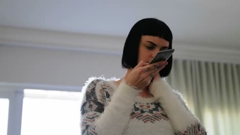 mujer hablando por teléfono móvil en la sala de estar 4k