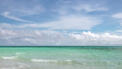 Ein-Horizont-Aus-Klaren,-Blauen,-Türkisfarbenen-Ozeanwellen-Mit-Weißen,-Flauschigen-Wolken-Am-Strahlend-Blauen-Himmel-In-Den-Tropen