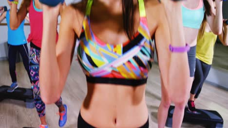 mujeres sonrientes haciendo step aerobics