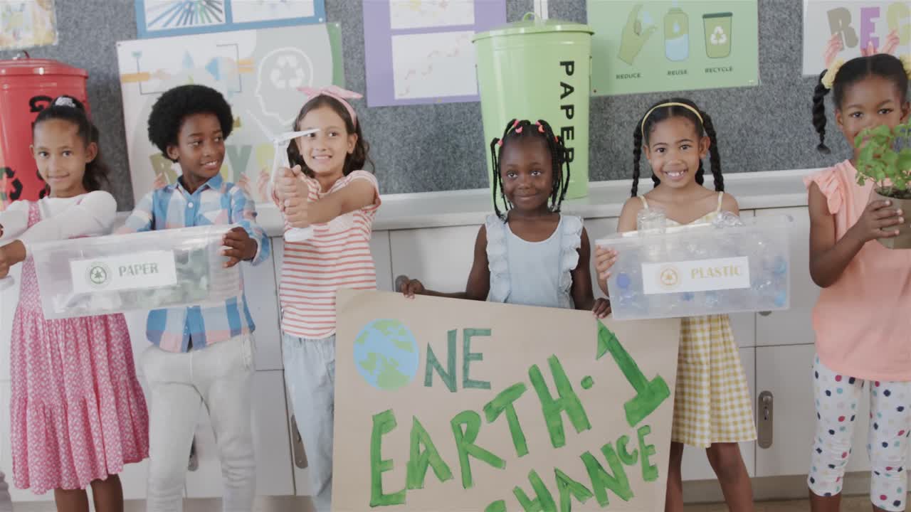 Ritratto di bambini felici di diverse origini in una classe di sensibilizzazione all'ecologia della scuola elementare, al rallentatore.