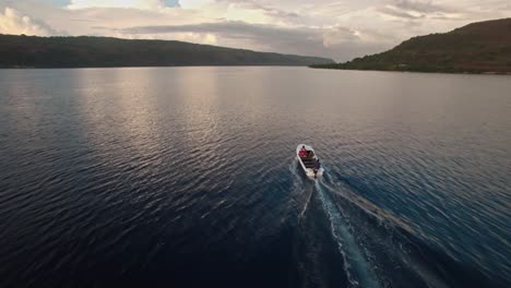 vista aérea sobre un increíble paisaje crepuscular con lancha motora navegando en una laguna marina tropical