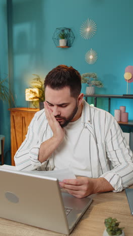 Amazed businessman opening envelope reading bad news in letter feels upset bankruptcy at home office
