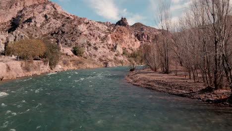 drone advancing over the beautiful atuel river and its rapids, with the backdrop of majestic mountains