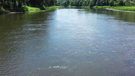 Luftaufnahme:-Langsamer-Flug-über-Dem-Fluss-Mit-Sonnenreflexion-Auf-Der-Wasseroberfläche-Mit-Wirbeln-Und-Strudeln