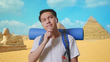 close up of asian male hiker with mountaineering backpack thinking about something and looking around while traveling in pyramid of giza