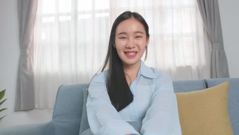 asian woman talking to camera in home living room, video in 4k