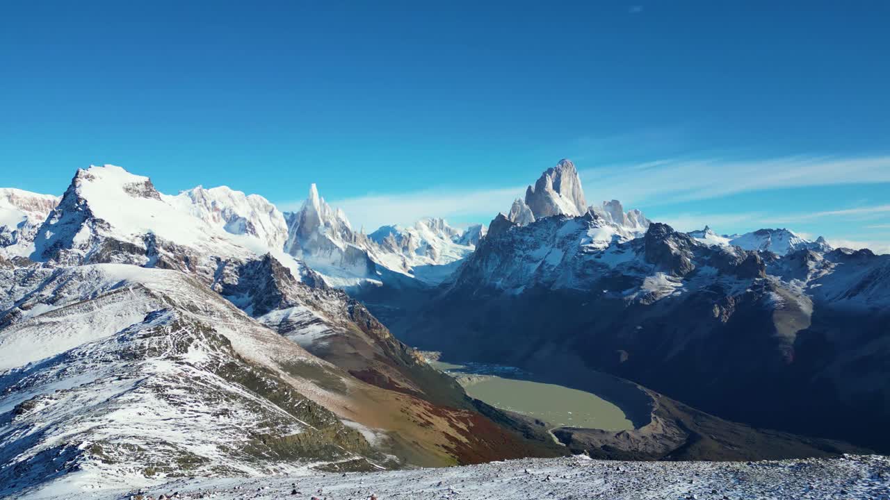 Aerial footage of Laguna Torre in El Chaltén, Argentina. Snow-covered Fitz Roy and Cerro Torre rise under a clear sky. A breathtaking Patagonian panorama at summer’s end, captured in stunning 4K