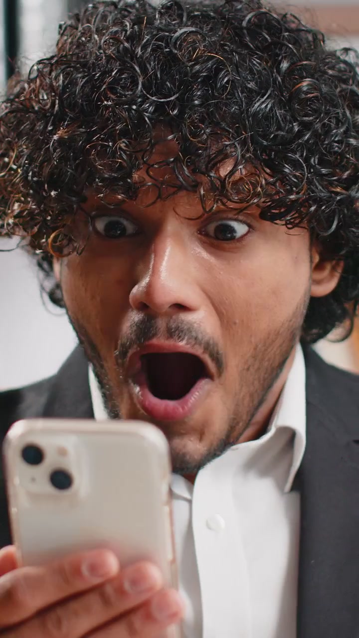 Uomo d'affari scioccato da una vittoria improvvisa a un gioco su smartphone, vincita alla lotteria, raggiungimento dell'obiettivo, buone notizie