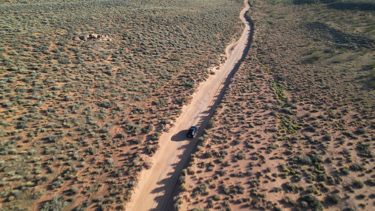 Aerial View of Car Driving on Desert Road