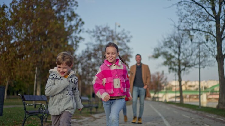 Children Running with Father in Autumn Park