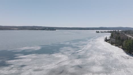 ice on frozen water of lake magog starting to melt on a sunny day in quebec, canada