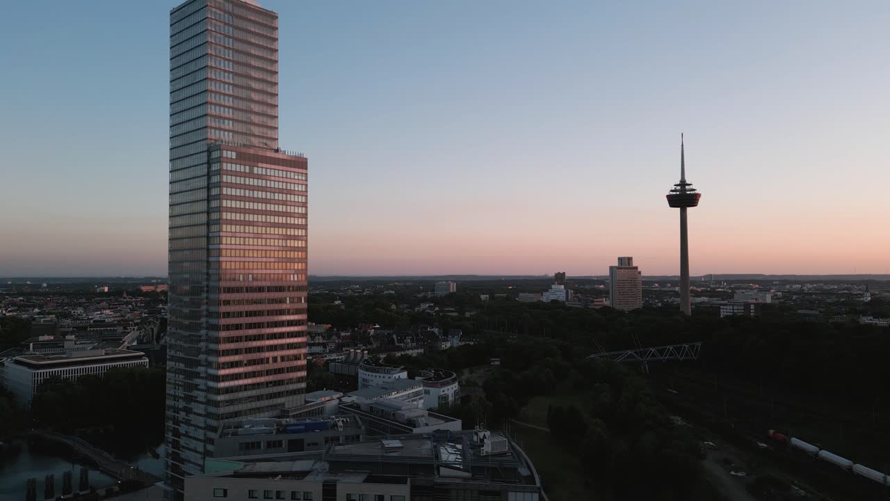 colonia, alemania - vista de pájaro en vuelo ascendente de un parque de medios de negocios y rascacielos con una vista panorámica y una torre de televisión en el fondo