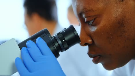 female scientist using microscope in laboratory 4k