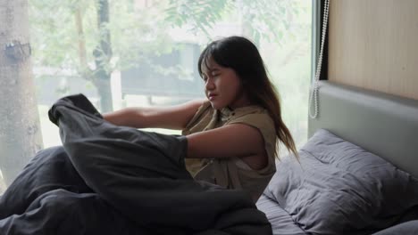 indonesian girl waking up in a room with a view of the forest