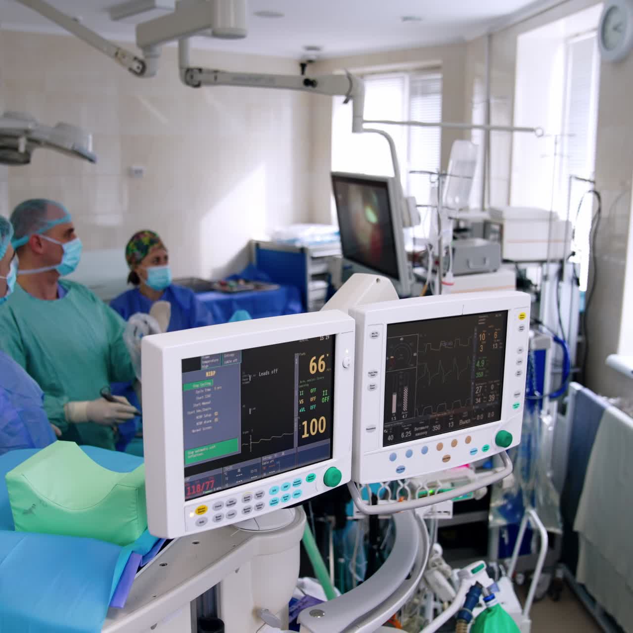 Attrezzature mediche in funzione in una sala operatoria moderna. Vista dall'alto. Team di medici che operano sullo sfondo.