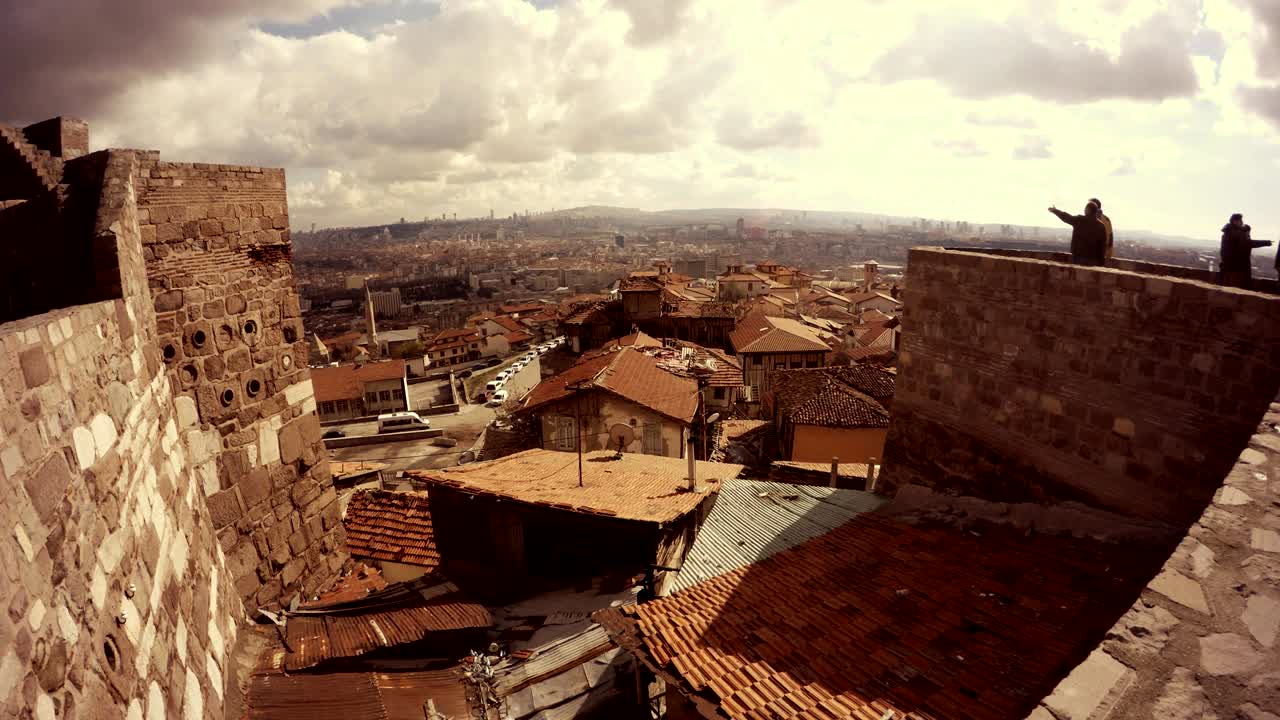 Vista de la Ciudadela de Hisar con sus murallas y casas antiguas de tejados de teja en un día nublado, con turistas paseando, Ankara