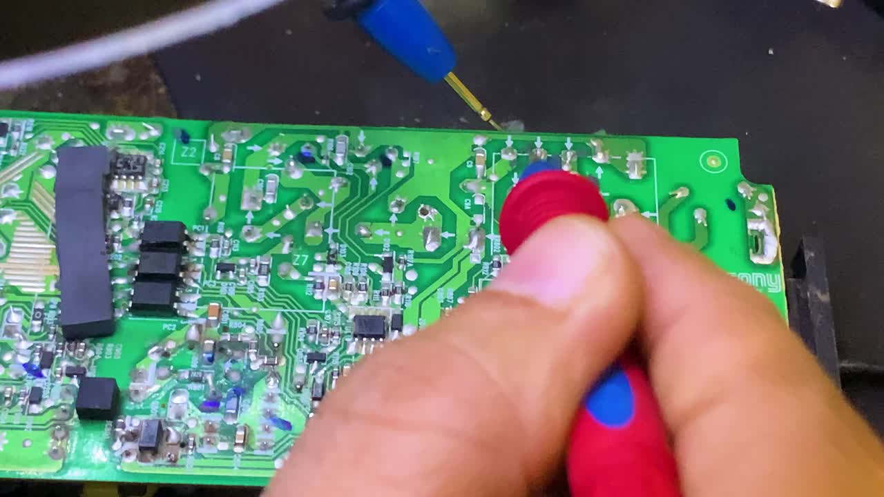 기술자는 전기를 측정하고 전압계로 회로 기판을 검사합니다.