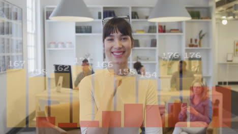 animación de gráficos con números cambiantes sobre una mujer biracial sonriente de pie en la oficina