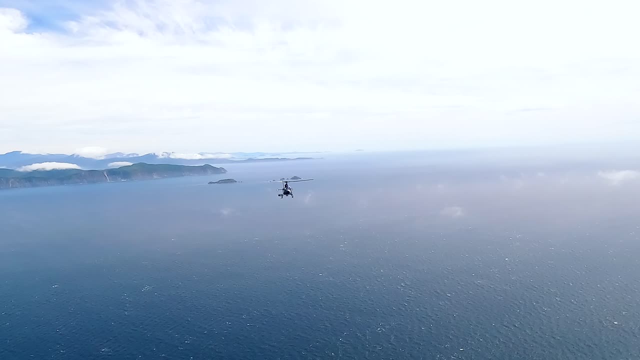 Helicopter flying high over the Cook Strait and white clouds towards the South Island of New Zealand
