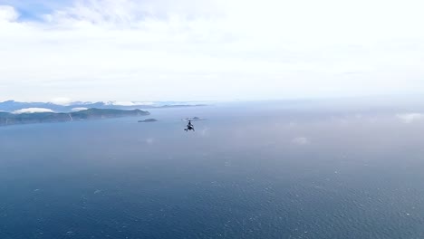 helicopter flying high over the cook strait and white clouds towards the south island of new zealand