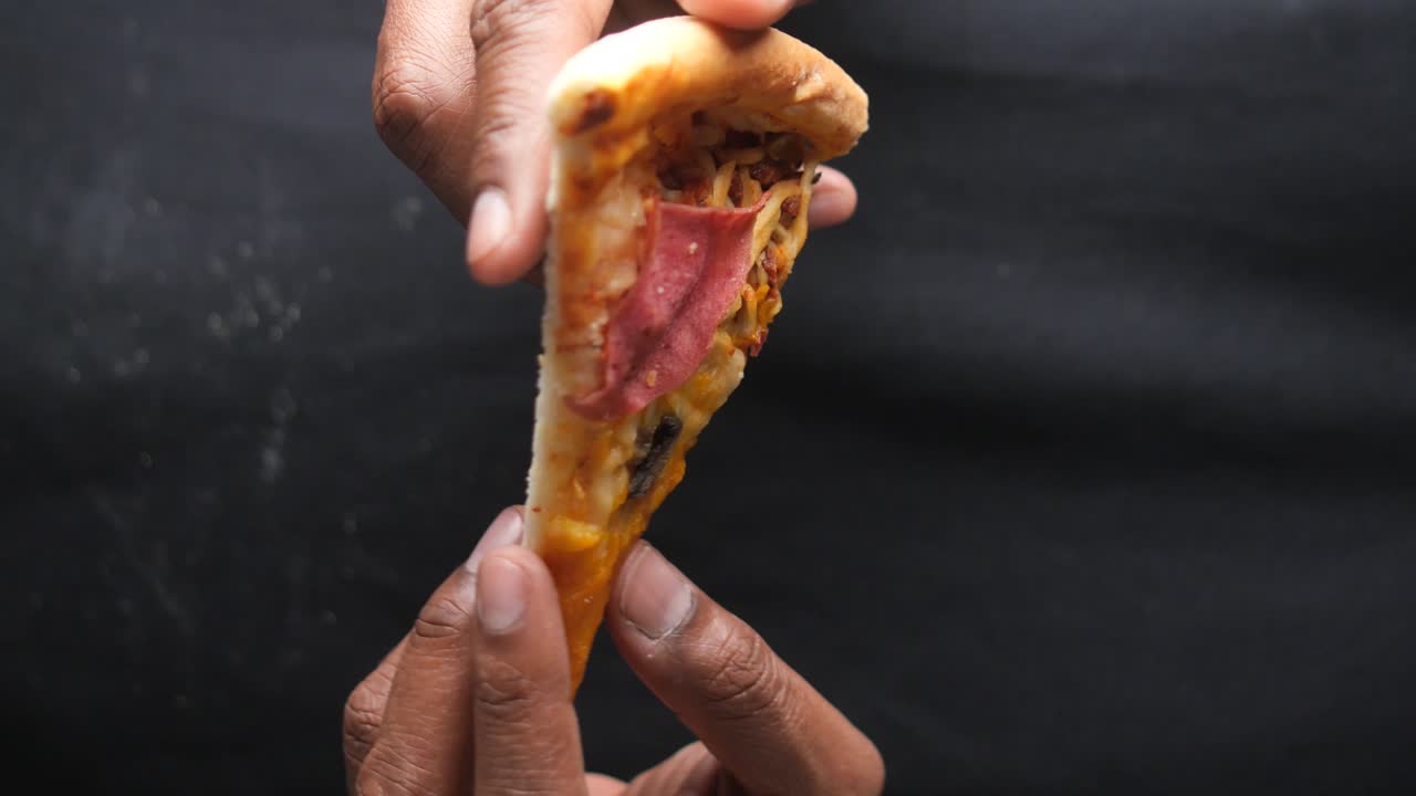 Pizza Slice Held in Hands