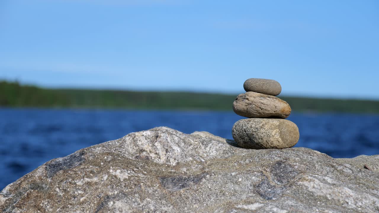 three rocks piled on each other. Peaceful lake scenery