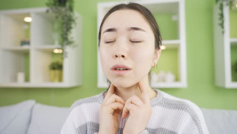 young woman with sore and swollen throat feels pain.