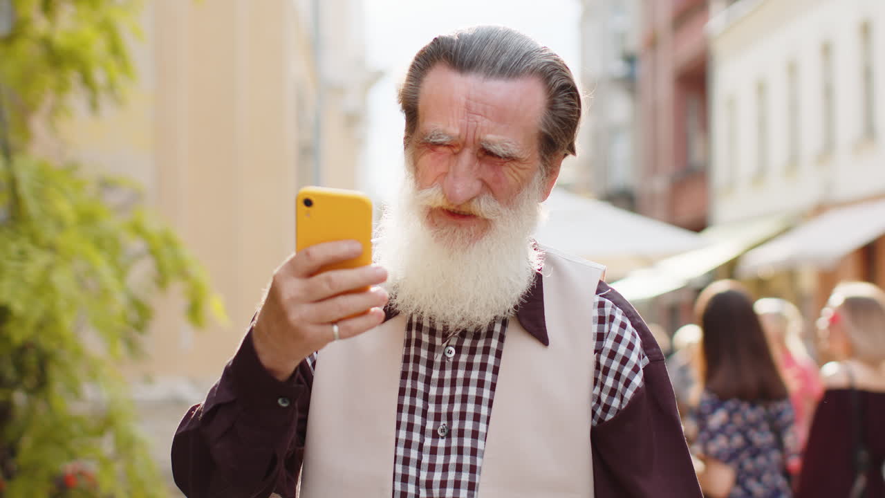 Surprised elderly old man use smartphone loses bad news fortune loss fail outdoors in city street