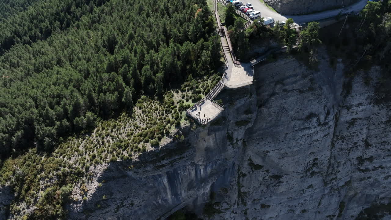 turistas de turismo en la plataforma de observación del borde del acantilado con vistas al terreno montañoso de cataluña, vista aérea sobre la parte superior