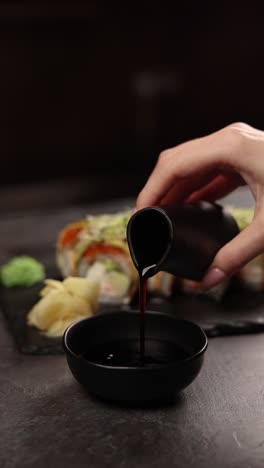 pouring soy sauce over sushi