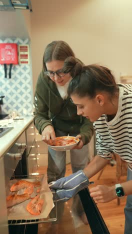 dos mujeres cocinando camarones en el horno