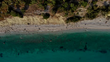 unspoiled shoreline with rocky beach washed by calm clean sea water on emerald colors