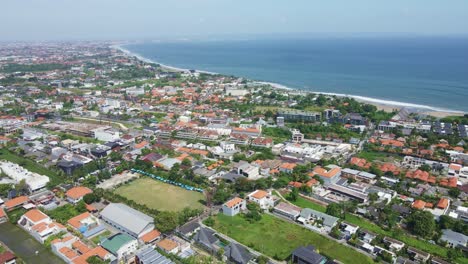 aerial view of berawa, canggu, bali, indonesia with real estate, hotels, villa, beach clubs and bukit, uluwatu at the background